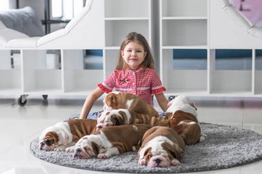 Küçük bir kız ve bulldog sevimli yavru arasındaki dostluk