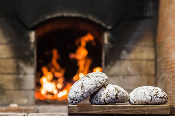 Pain croustillant couché sur le bord du poêle russe sur le foyer — Photo