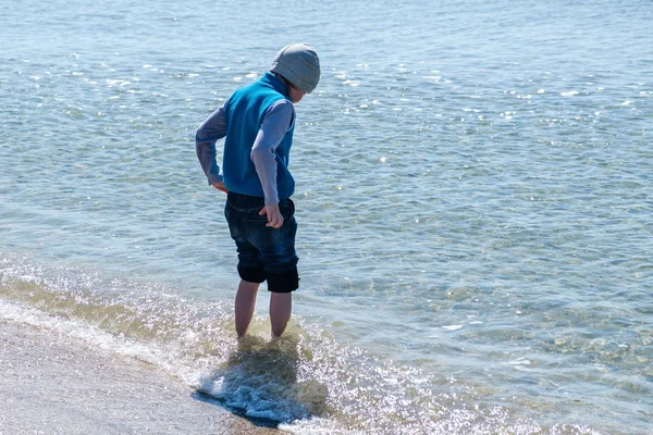 Szczęśliwy, mały chłopiec, bieganie i skakanie w fale na plaży nad Morzem Czarnym — Zdjęcie stockowe