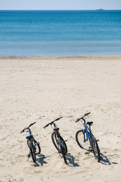 Trzy rowery są na plaży na tle morza — Zdjęcie stockowe