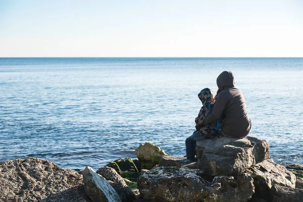 Widok z tyłu matki i syna, spacery nad brzegiem morza — Zdjęcie stockowe
