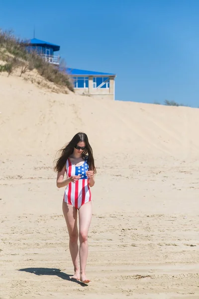 Patriota hermosa mujer caminando en la playa en julio —  Fotos de Stock
