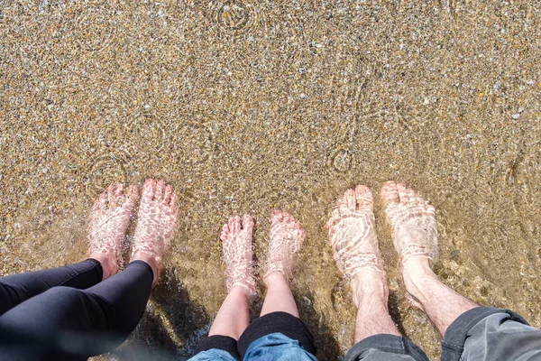 Familia de pies en el mar en la playa de arena. Concepto de vacaciones —  Fotos de Stock