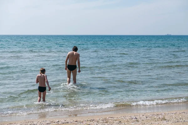 Pai e filho brincando no mar — Fotografia de Stock