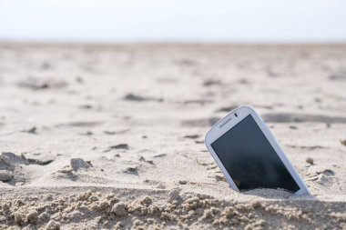 Mobil dokunmatik telefon bir plaj kum