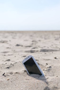 Mobil dokunmatik telefon bir plaj kum