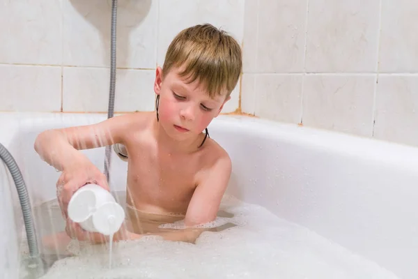 Piękne dziecko relaksującą kąpiel z pianą i korzystania z kosmetyków — Zdjęcie stockowe