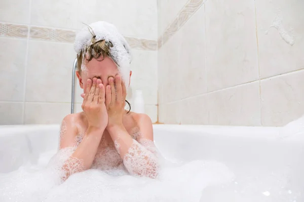 Litet barn tvätta håret i badet — Stockfoto