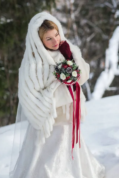Schöne Braut mit Blumenstrauß im Freien an einem Wintertag — Stockfoto