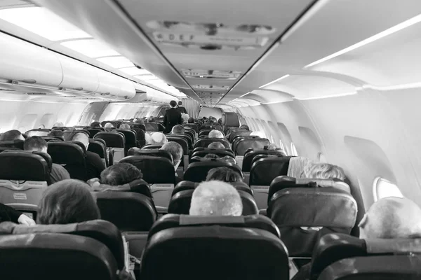Задний вид пассажиров на стульях внутри самолета — стоковое фото