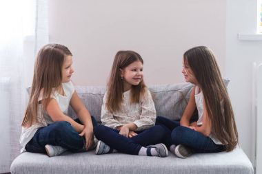 Kanepe ve dostluk kavramı üzerinde oturan üç mutlu kız portresi