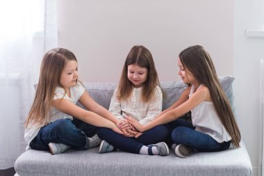 Kanepe ve dostluk kavramı üzerinde oturan üç mutlu kız portresi