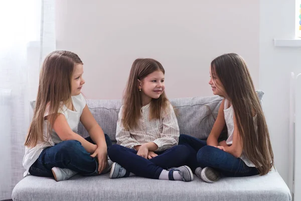 Kanepe ve dostluk kavramı üzerinde oturan üç mutlu kız portresi