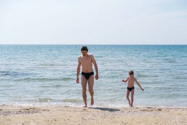 Baba ve oğul denizde oynuyorlar.