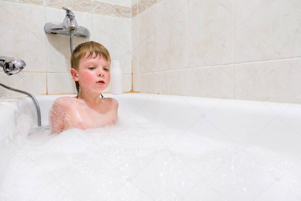 a child playing in a bubble bath at home