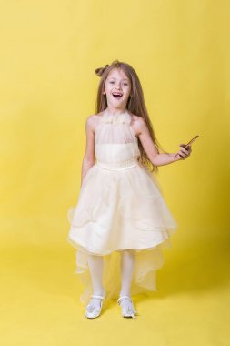 Sarı bir arka plan üzerinde elbiseli genç kız kendilerini telefonla fotoğrafı