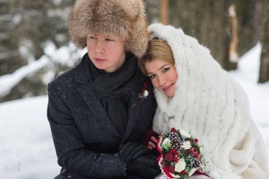 Gelin ve damat köpek kış manzara arka plan üzerinde oturan, şık güzel genç Çift