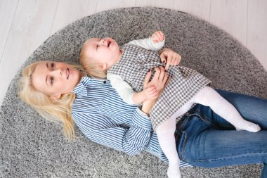 Mutlu gülümseyen anne ve bebek evde yatakta uzanır, üst manzara