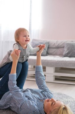Şirin bebeği tutarak yerde yatarken anne