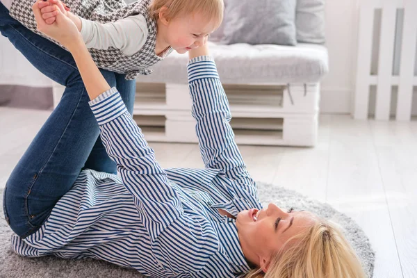 Mère couchée sur le sol tenant son mignon bébé — Photo