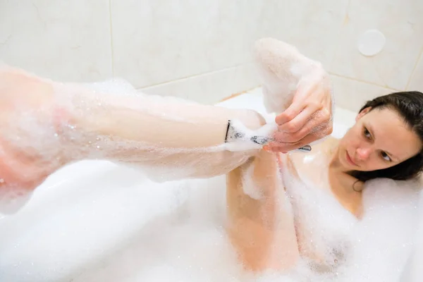 Hermosa mujer joven disfrutando de baño agradable con espuma — Foto de Stock