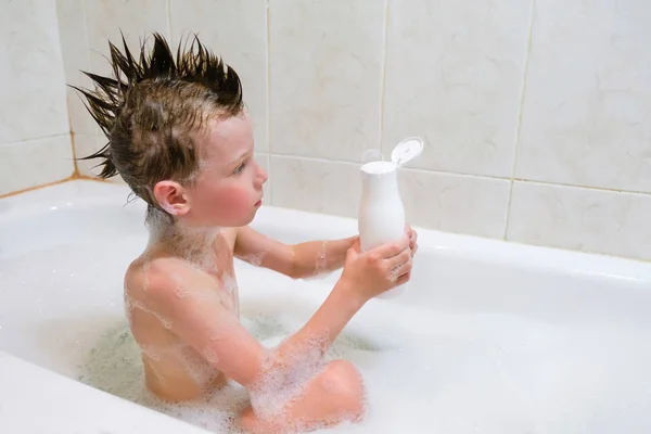 Красивый ребенок принимает расслабляющую ванну с пеной и с помощью косметики — стоковое фото