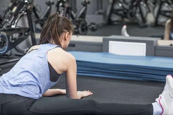 Achteraanzicht van sportieve vrouw doen stretching oefening — Stockfoto