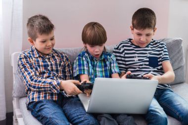 Divan, laptop ile oynarken çocuklarım evde oturuyor