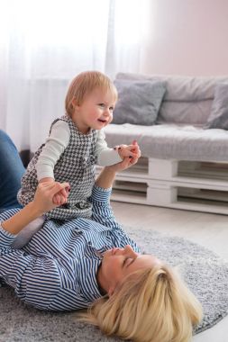 Şirin bebeği tutarak yerde yatarken anne