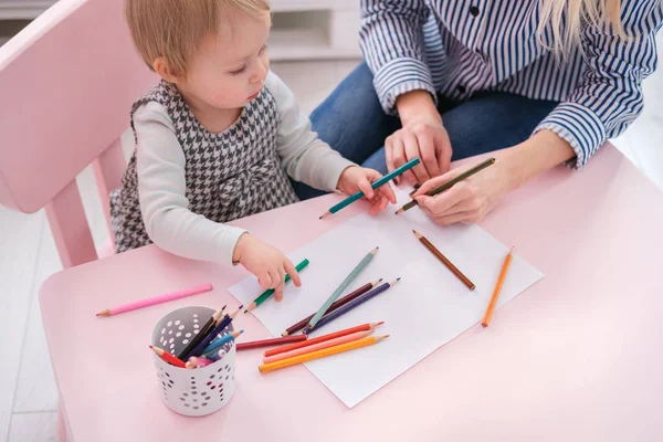 Attraente giovane madre e sua figlia stanno disegnando — Foto Stock