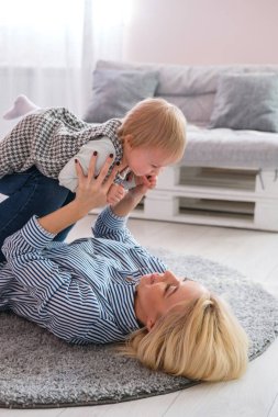 Şirin bebeği tutarak yerde yatarken anne