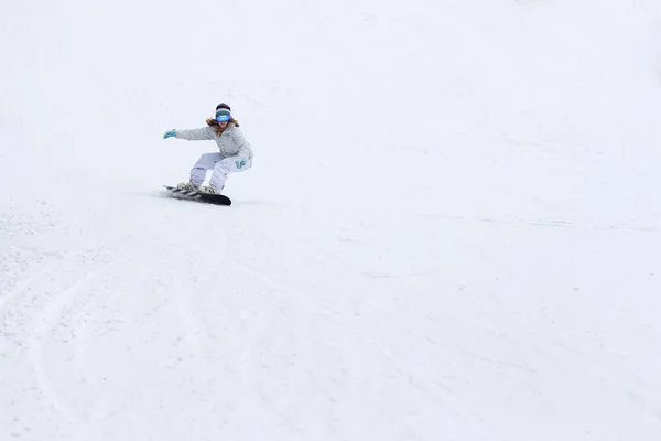 Mujer snowboarder balanceando las pistas en invierno — Foto de Stock
