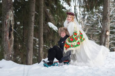 Damat ve gelin büyük ahşap kızak ile soğuk kış ormandaki