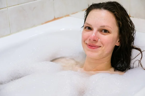 Jong mooi meisje in een bad met schuim — Stockfoto