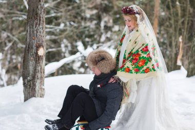 Damat ve gelin büyük ahşap kızak ile soğuk kış ormandaki