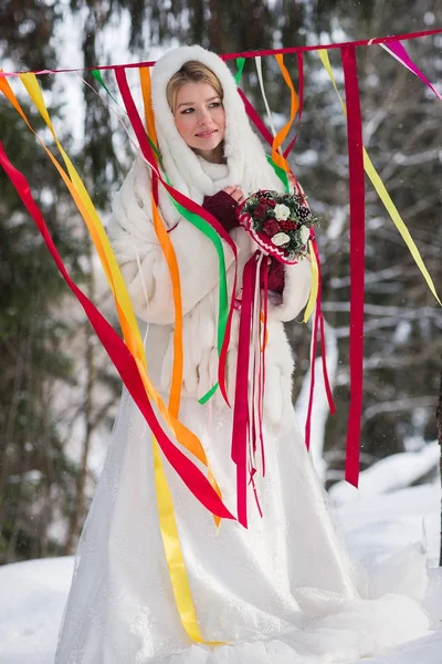 Schöne Braut mit Blumenstrauß im Freien an einem Wintertag — Stockfoto