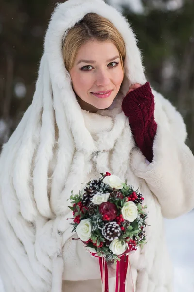 Schöne Braut mit Blumenstrauß im Freien an einem Wintertag — Stockfoto