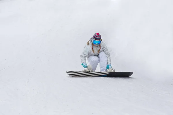 Νεαρή γυναίκα με snowboard κάθεται στην πλαγιά του λόφου — Φωτογραφία Αρχείου