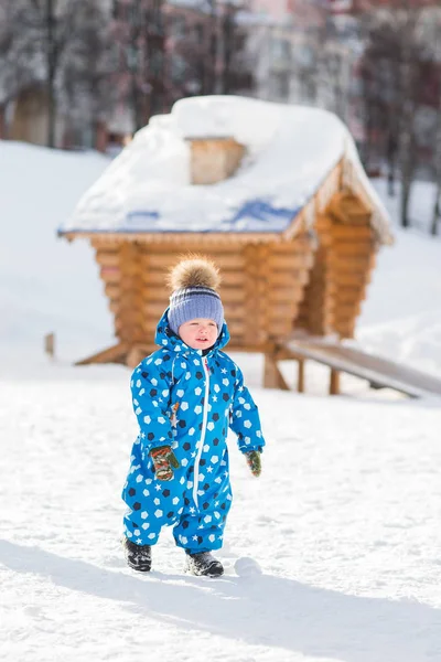 Маленький милый малыш гуляет на свежем воздухе в прекрасный солнечный зимний день — стоковое фото