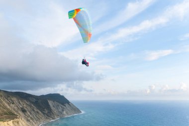 Deniz ve dağlar, güzel manzaralı yakınındaki tandem paraşütler uçan