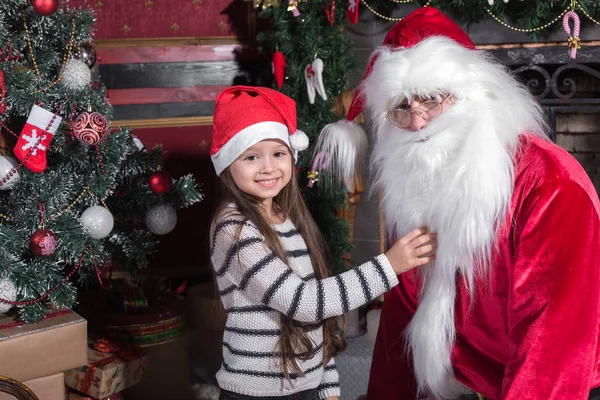 Santa Claus y linda chica preparándose para la Navidad . — Foto de Stock