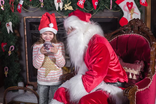 Santa Claus a roztomilá dívka se chystá na Vánoce. — Stock fotografie