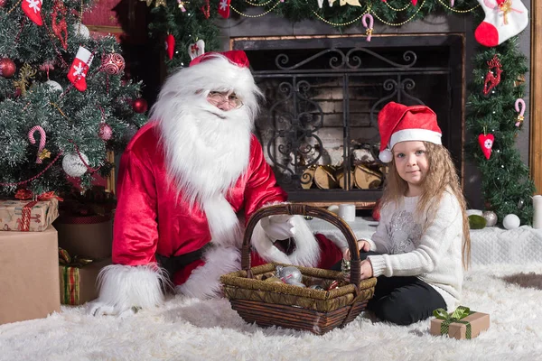 Santa Claus y linda chica preparándose para la Navidad . — Foto de Stock