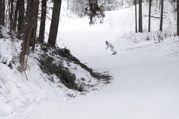 Jonge vrouw snowboarder in beweging op snowboard in de bergen — Stockfoto