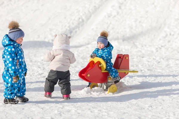 Niños hermanos gemelos caminando en invierno jugando con otros niños —  Fotos de Stock