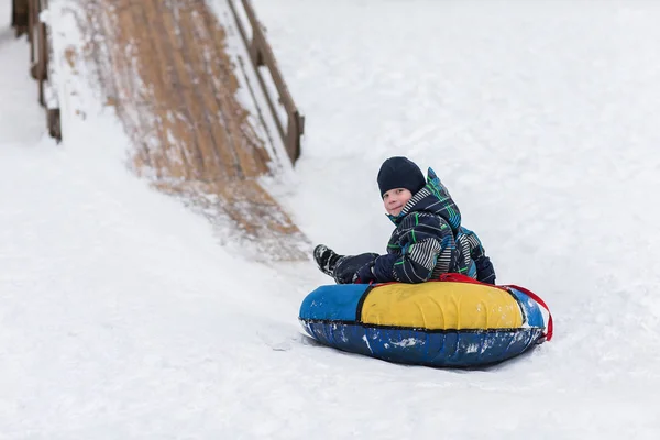 幸せな子供が氷の山冬の管のために向かっています。 — ストック写真