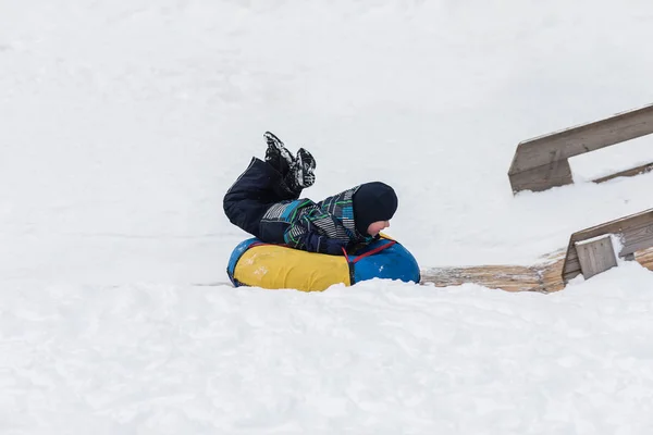 Niño feliz se dirige a la montaña de hielo para tubería en el invierno — Foto de Stock