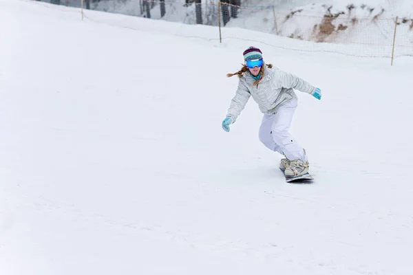 Jovem snowboarder em movimento em snowboard nas montanhas — Fotografia de Stock