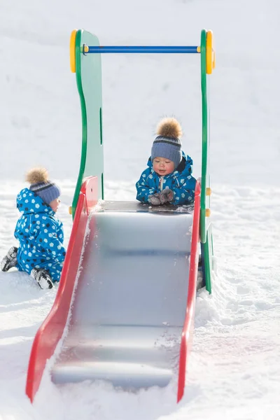 Zwillingsjungen laufen im Winter im Park und rollen mit eiserner Rüstung — Stockfoto
