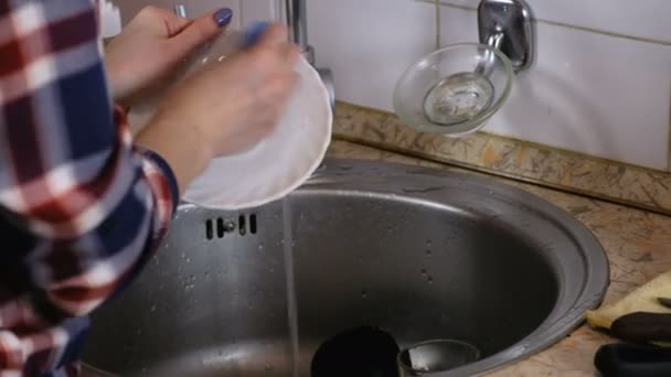 Vrouw wast een schoteltje en vangt het glas vallen in de gootsteen. — Stockvideo